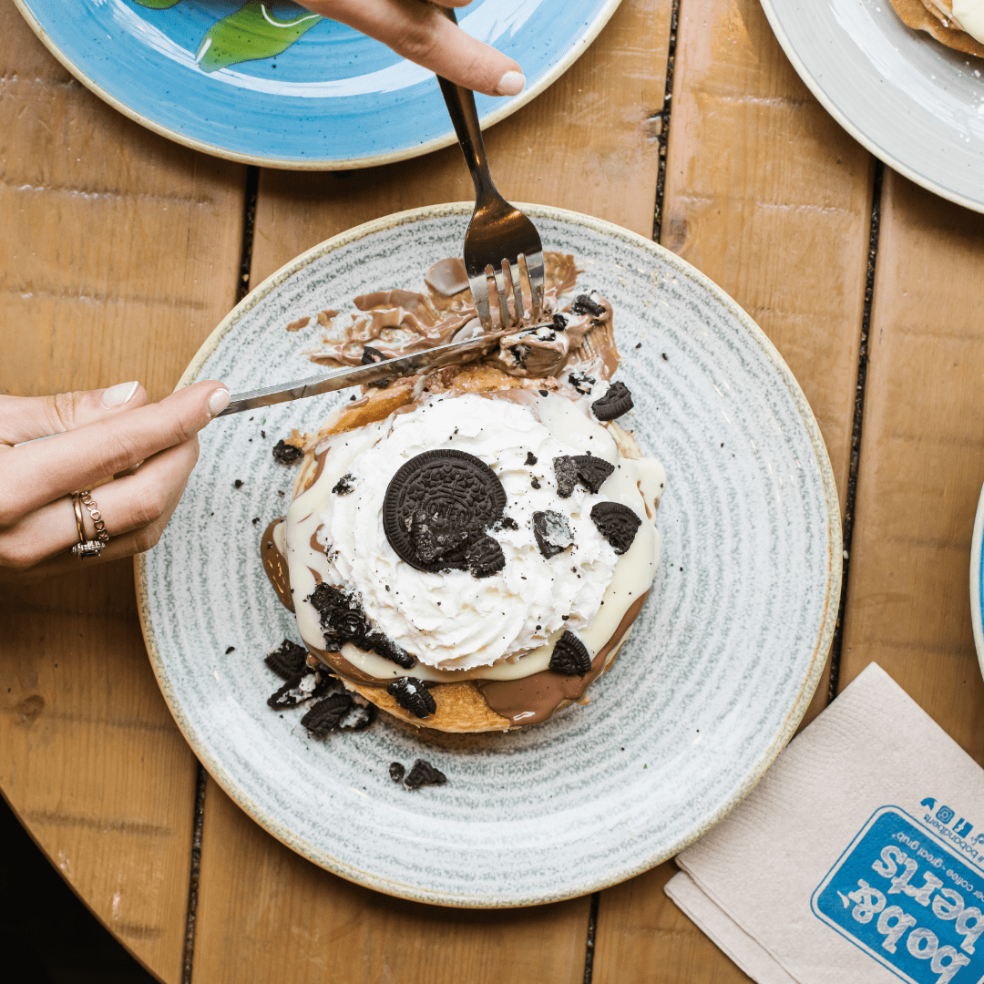 A girl eating an Oreo pancake stack from Bob & Berts photographed by Rapid Agency
