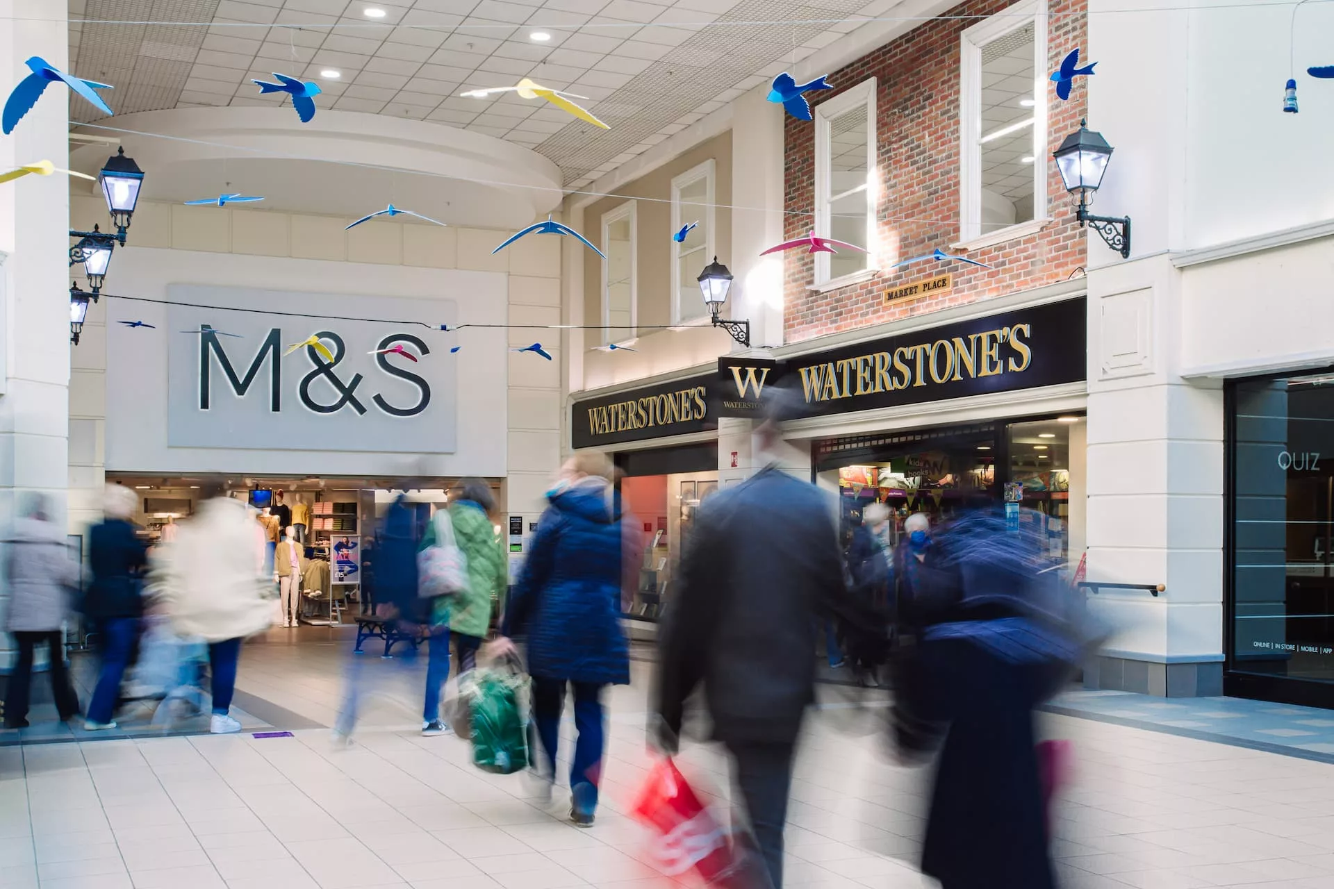 An interior shot of the main mall in Fairhill Shopping Centre showing M&S and Waterstones